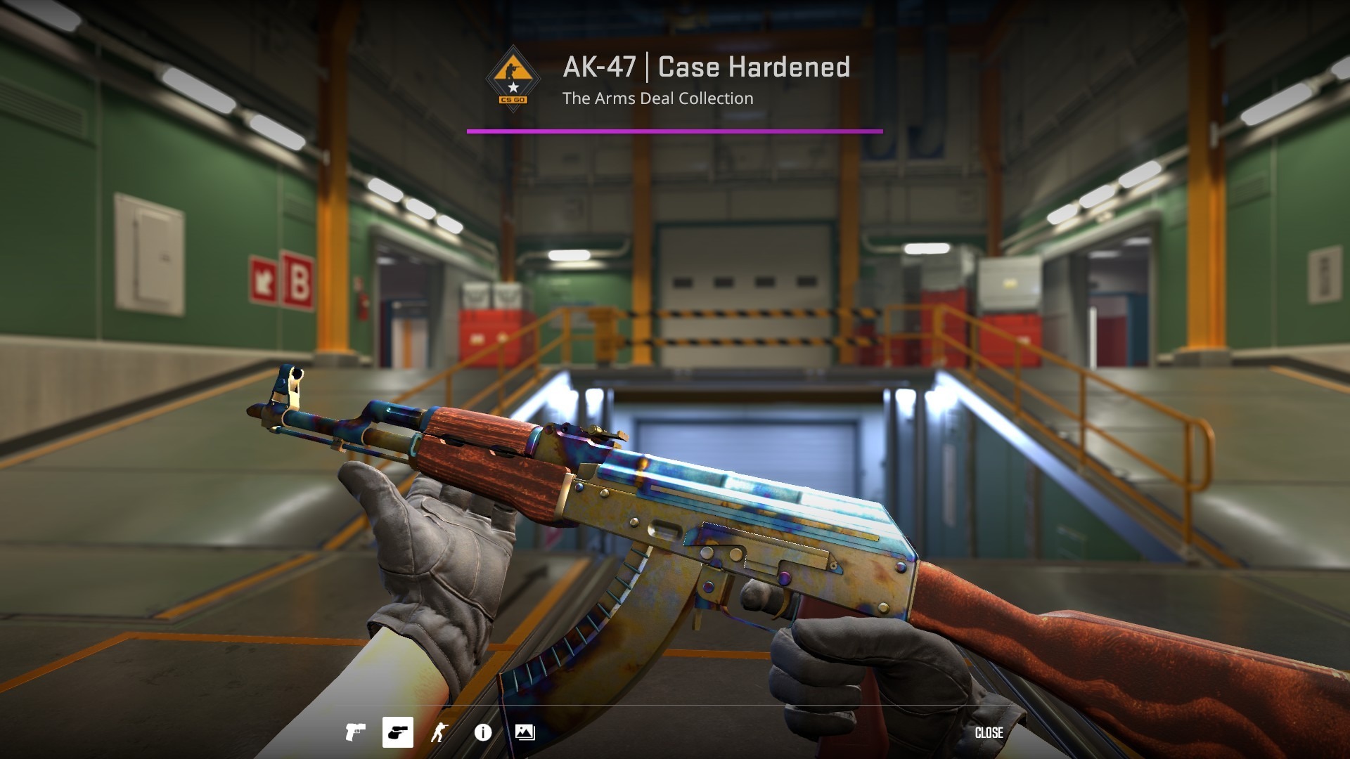 First-person view of an AK-47 | Case Hardened with blue and gold metal held in gloved hands on the CS2 inspect screen