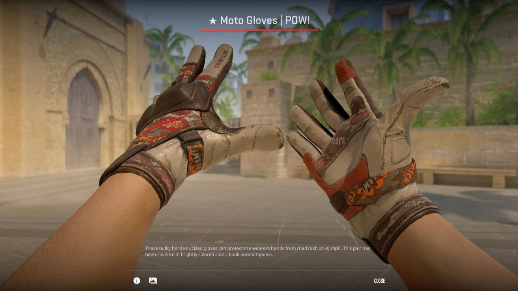Moto Gloves | POW! in worn cream leather with orange and red comic-style graphics, shown in the CS2 inspect screen