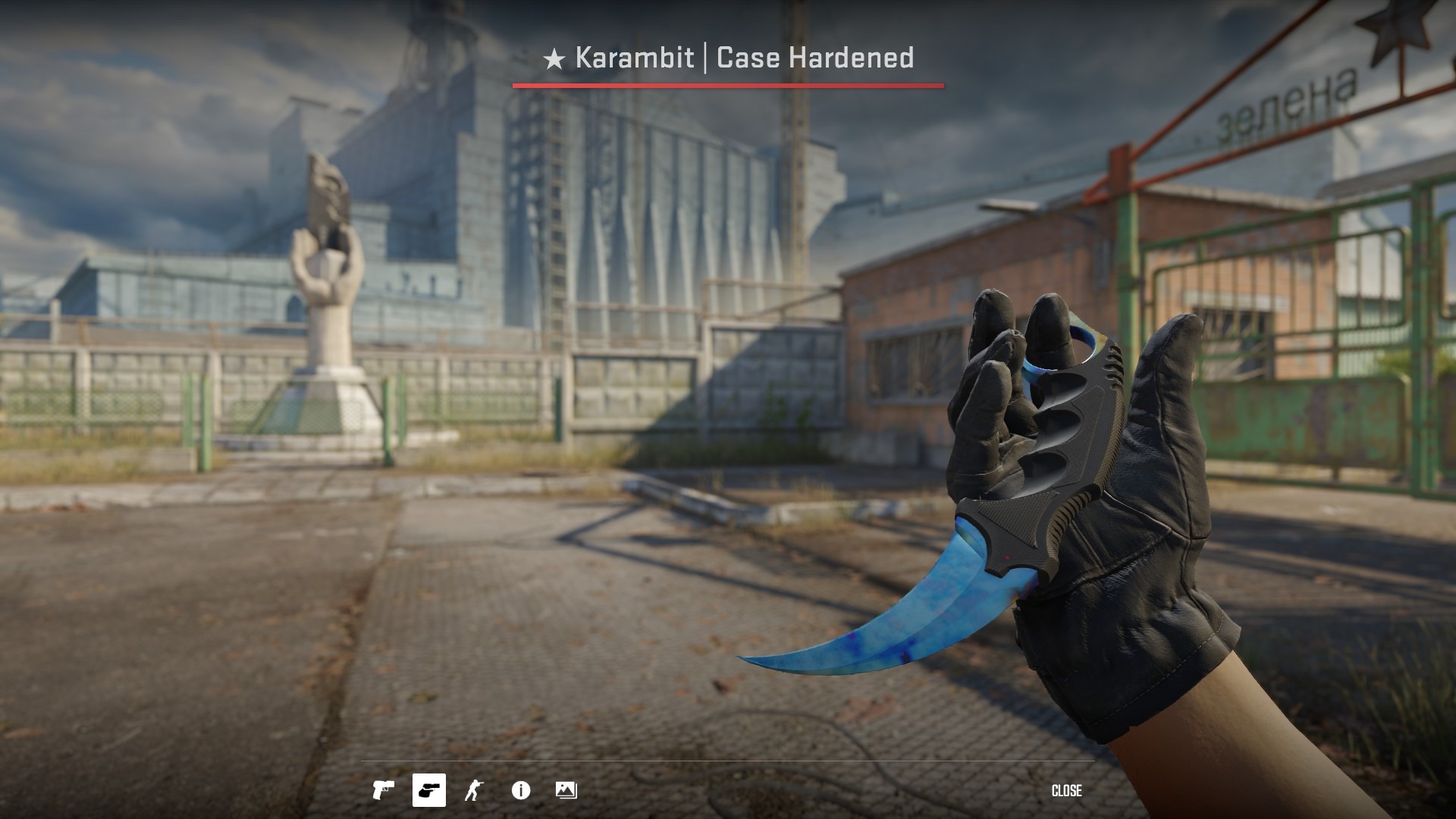Karambit Case Hardened Blue Gem knife inspect view against a run-down urban CS2 map background
